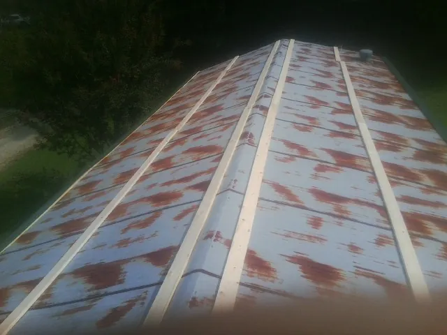 Rusted metal roof panels with new wood purlins before replacement — Storm Damage Roof Repair in Boykins by Roofing Brothers